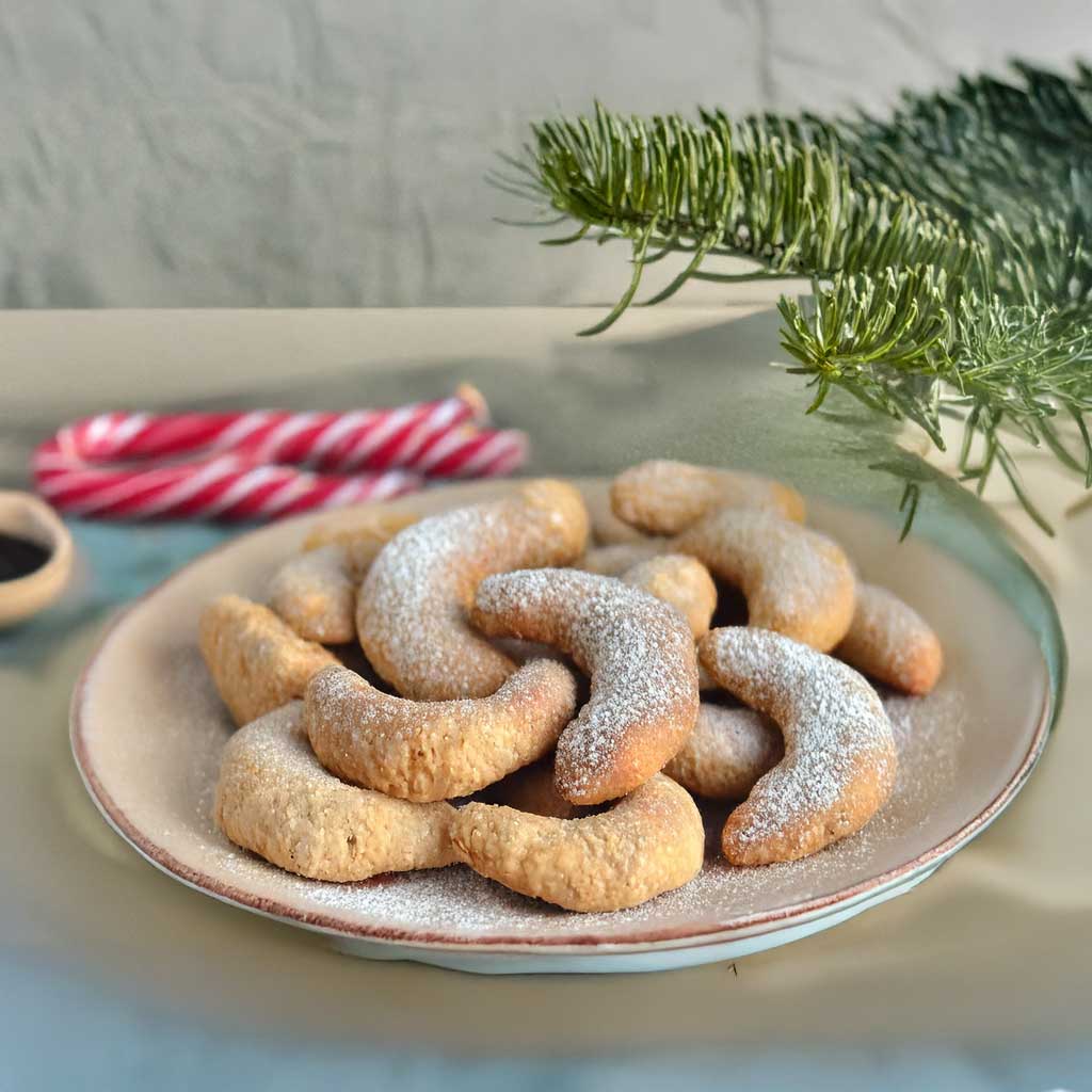 Vanillekipferl auf einem Teller mit Puderzucker